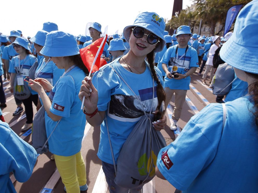 PHOTO: Employees of the Chinese company Tiens attend a parade on May 8, 2015 in Nice, France.