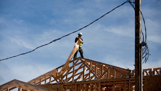 PHOTO: A worker installs roofing material while standing on the roof a house in Rancho Santa Fe, Calif., Dec. 21, 2012.