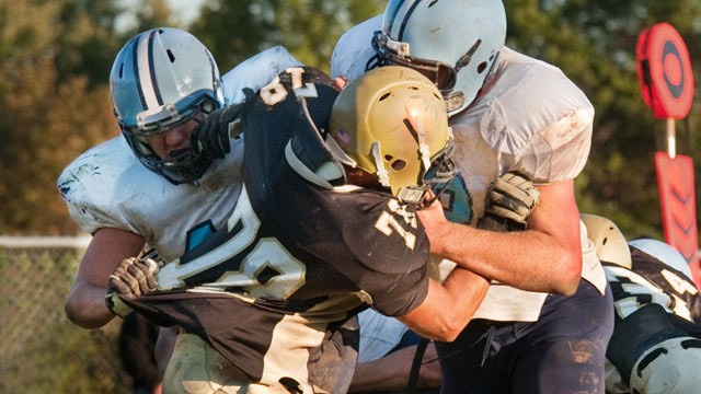 PHOTO: Football players block opponent
