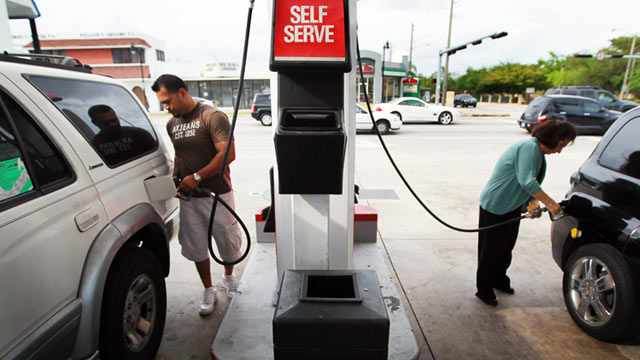 PHOTO: Two people pump gas at the Ugas station, March 6, 2011, in Miami.