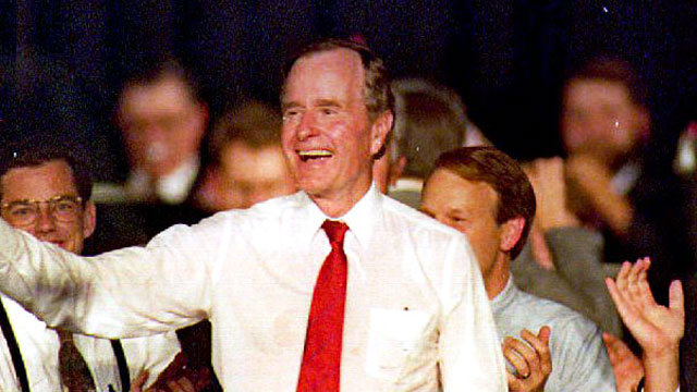 PHOTO: U.S. President George Bush (C) holds a sign Sept. 17, 1992 that were handed out during an indoor rally in Enid, OH.