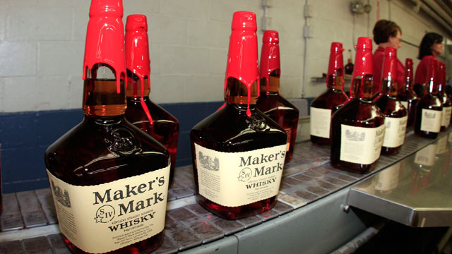 PHOTO: Bottles of Makers Mark Distillery Inc. bourbon whisky sit on a conveyor belt after being hand dipped with their signature red wax at their distillery in Loretto, Kentucky, U.S., Jan. 4, 2011.