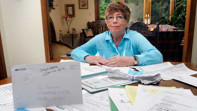 PHOTO: Lee Barrows poses for a portrait with medical bills at her home in Canton, Connecticut, U.S., on July 2, 2010.