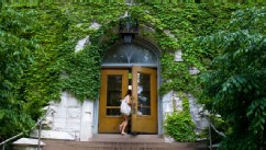 PHOTO: College student walking through door of Northwestern University building.