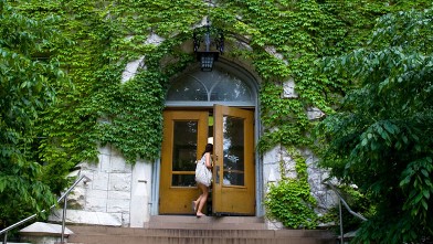 PHOTO: College student walking through door of Northwestern University building.
