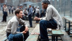 PHOTO: Tim Robbins and Morgan Freeman sitting outside on the benches playing checkers and talking in a scene from the film 'The Shawshank Redemption'.