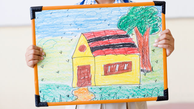 PHOTO: Child holding a framed drawing