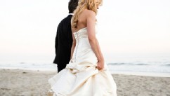 PHOTO: Bride and groom walking on beach