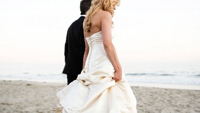 Bride and groom walking on beach