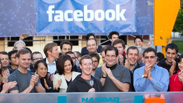 PHOTO: Mark Zuckerberg, chief executive officer of Facebook Inc., center, Sheryl Sandberg, chief operating officer of Facebook, center left, and Robert Greifeld, chief executive officer of Nasdaq OMX Group Inc., center right, ring the opening bell for tra