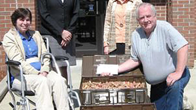 PHOTO: Tom and Sandra Daigle show off the pennies they brought to the bank to make their final mortgage payment.