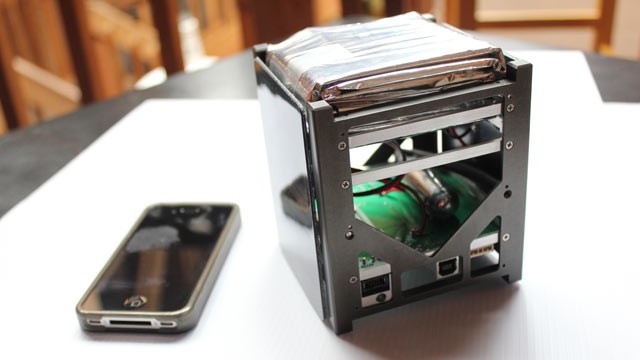 PHOTO: This undated handout image shows the real SkyCube model with the actual size of the satellite compared to an iPhone.