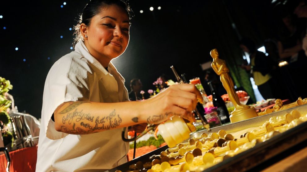 PHOTO: Pastry chef Jessica Contreras sprays gold dust on chocolate Oscar statues at the Governors Ball Press Preview for the 86th Oscars, on Thursday, Feb. 20, 2014, in Los Angeles.