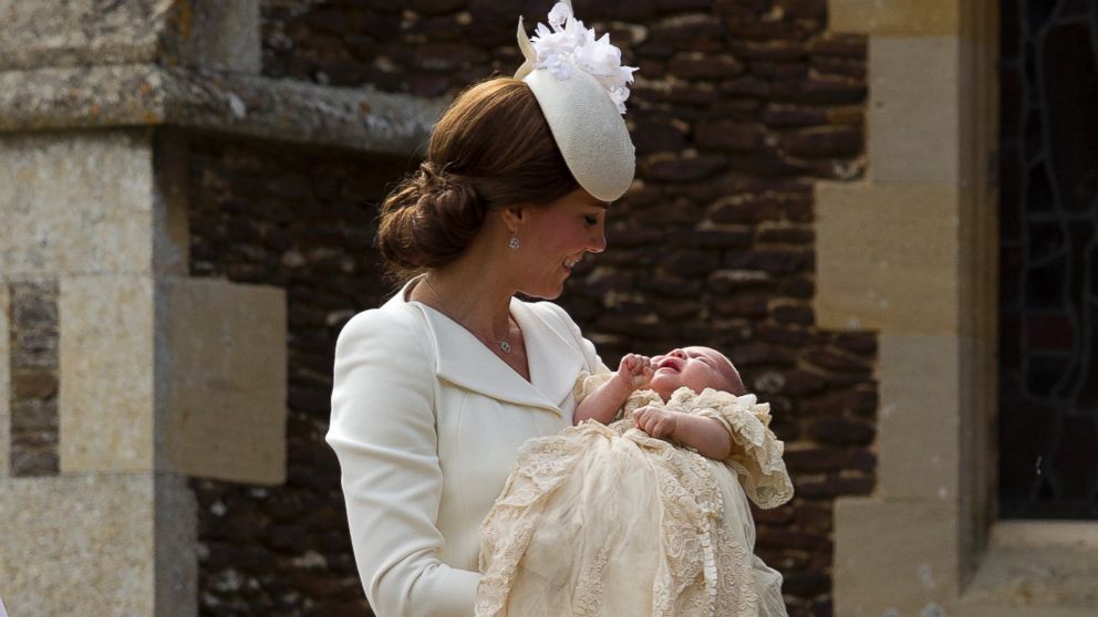 PHOTO: Britains Kate the Duchess of Cambridge carries Princess Charlotte after taking her out of a pram as they arrive for Charlottes Christening at St. Mary Magdalene Church in Sandringham, England, July 5, 2015. 