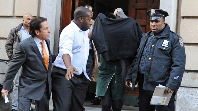 PHOTO: Lindsay Lohan, second from right, is escorted from the 10th Precinct police station, with her face shielded, Nov. 29, 2012, in New York after being charged for allegedly striking a woman at a nightclub.