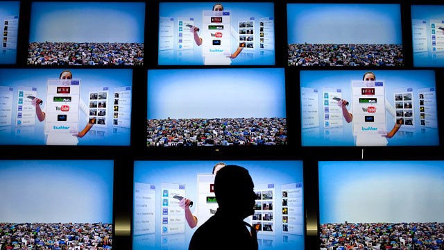 PHOTO: An attendee passes LG Electronics Inc. Smart TV displays during the 2011 International Consumer Electronics Show (CES) in Las Vegas, Nevada, Jan. 7, 2011.