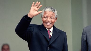 PHOTO: South African anti-apartheid leader Nelson Mandela waves to the press as he arrives at the Elysee Palace, June 7, 1990, in Paris, to have talks with French president Francois Mitterrand.