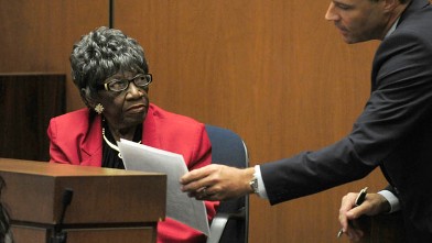 PHOTO: Deputy District Attorney David  Walgren hands Ruby Mosley, character witness and former patient of Dr. Conrad Murray, a statement during her testimony.