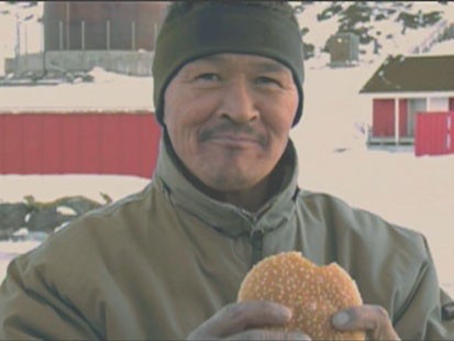 A picture of a man holding a hamburger.