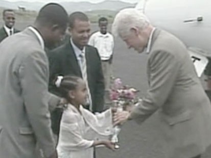 Little girl handing Bill Clinton flowers