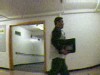VIDEO: A hidden camera image of a man walking through a dorm hallway.