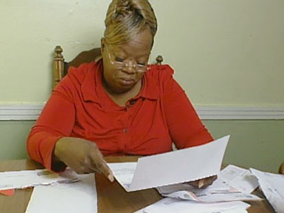 A picture of Lizzie Revels looking at her bills.