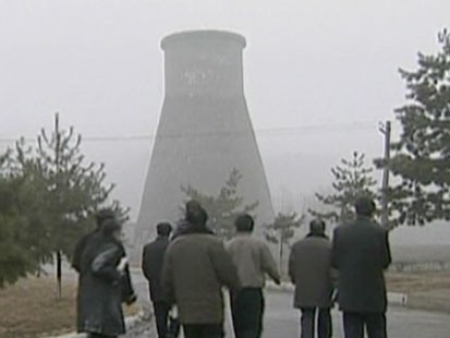 People walking towards cooling tower