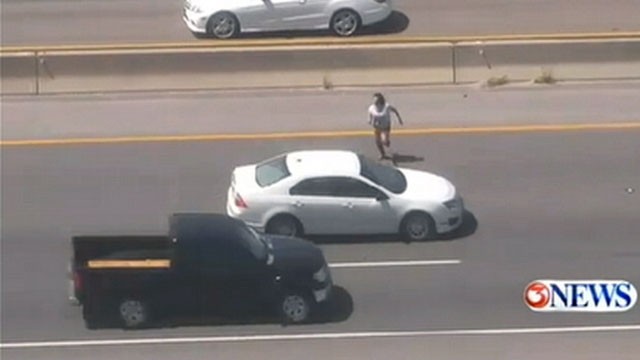 VIDEO: The female suspect ran across a 10-lane highway in Texas and is still on the loose.