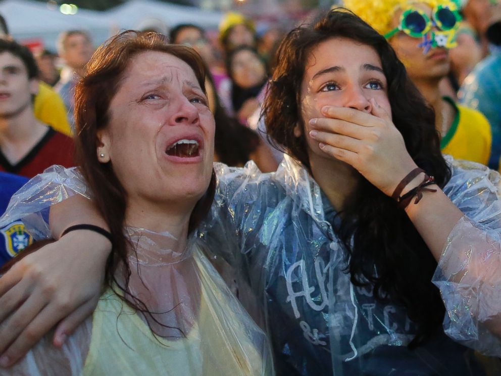 PHOTO: Brazil soccer fans cry as they watch their team lose 7-1 to Germany at a World Cup semifinal match on a live telecast inside the FIFA Fan Fest area on Copacabana beach in Rio de Janeiro, Brazil on July 8, 2014. 