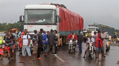 PHOTO: Stranded people stand behind a rope across the road that separates Guinea and Sierra Leone, and works as a makeshift border control checkpoint at Gbalamuya-Pamelap, Guinea, on Aug. 12, 2014. 