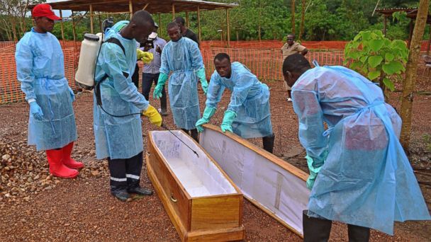 PHOTO: Sierra Leonese government burial team members are pictured wearing protective clothing while disinfecting a coffin at the Medecins Sans Frontieres facility in Kailahun, Sierra Leone on Aug. 14, 2014. 