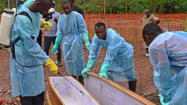 PHOTO: Sierra Leonese government burial team members are pictured wearing protective clothing while disinfecting a coffin at the Medecins Sans Frontieres facility in Kailahun, Sierra Leone on Aug. 14, 2014. 