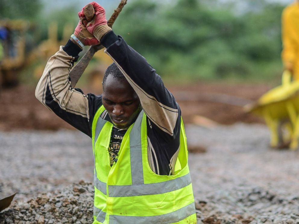 PHOTO: A worker of the International Committee of the Red Cross digs a hole with a pickaxe during the construction a brand new health center in Kenema, Sierra Leone on Aug. 25, 2014.