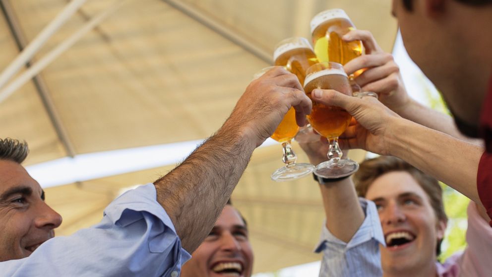 PHOTO: In this stock image, four men are pictured toasting outdoors.