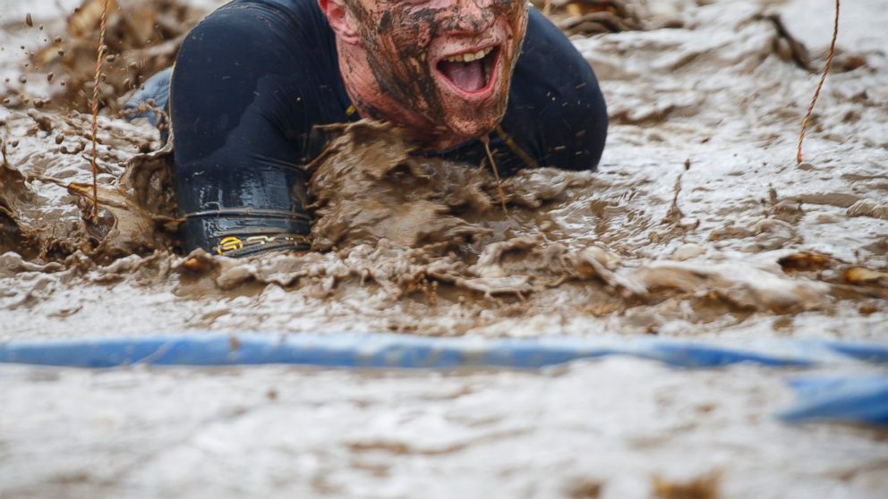 PHOTO: A competitor crawls in mud while competing in the Tough Mudder endurance race in Henley-on-Thames, England on April 27, 2014.
