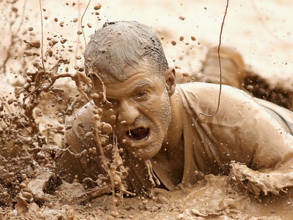 PHOTO: A competitor crawls through mud during Toughmudder at Phillip Island Grand Prix Circuit, March 23, 2014 in Phillip Island, Australia.