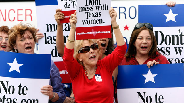 PHOTO: Mary Green, Peg Armstrong and Jan Perrault hold up signs during Womens Health Express, a bus event held in San Antonio, Texas, to protest the attempt to cut Planned Parenthood out of the states Womens Health Plan, March 6, 2012.