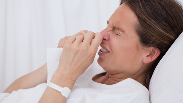 PHOTO: Woman in hospital bed sneezing