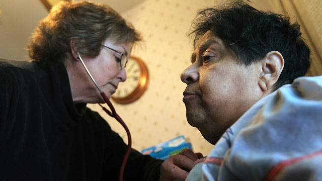 PHOTO: Registered nurse Susan Eager, left, checks the breathing of Jane Awise, who suffers from severe diabetes, while performing a home health care visit.
