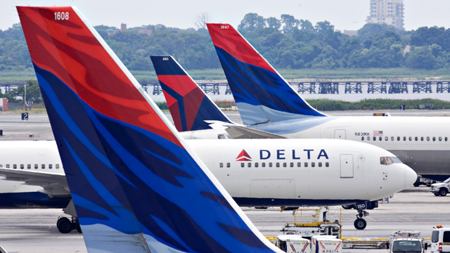 PHOTO: A Delta Air Lines plane taxis toward a gate between other Delta planes at John F. Kennedy International Airport in New York.