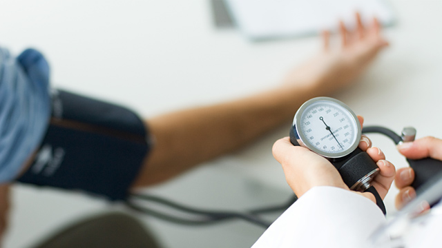 PHOTO: Doctor checking patients blood pressure