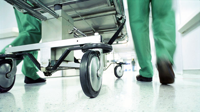 PHOTO: A gurney is rushed through hospital corridor.