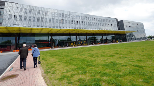 PHOTO: People walk in front of the hospital where a 65-year-old man, who returned from a trip from Dubai, was diagnosed with the deadly novel coronavirus, in Douai, France, May 8, 2013.