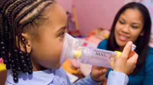 PHOTO A nurse works with a child during a home visit as part of the Community Asthma Initiative.