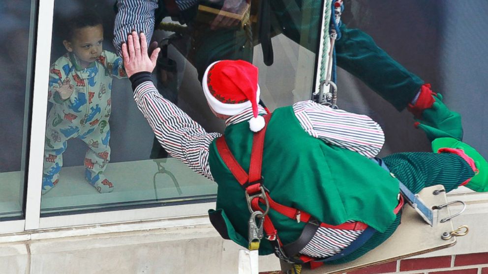 PHOTO: A toddler high-fives one of the elves through the window.