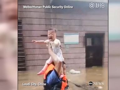 WATCH: Cop carries a baby above floodwaters