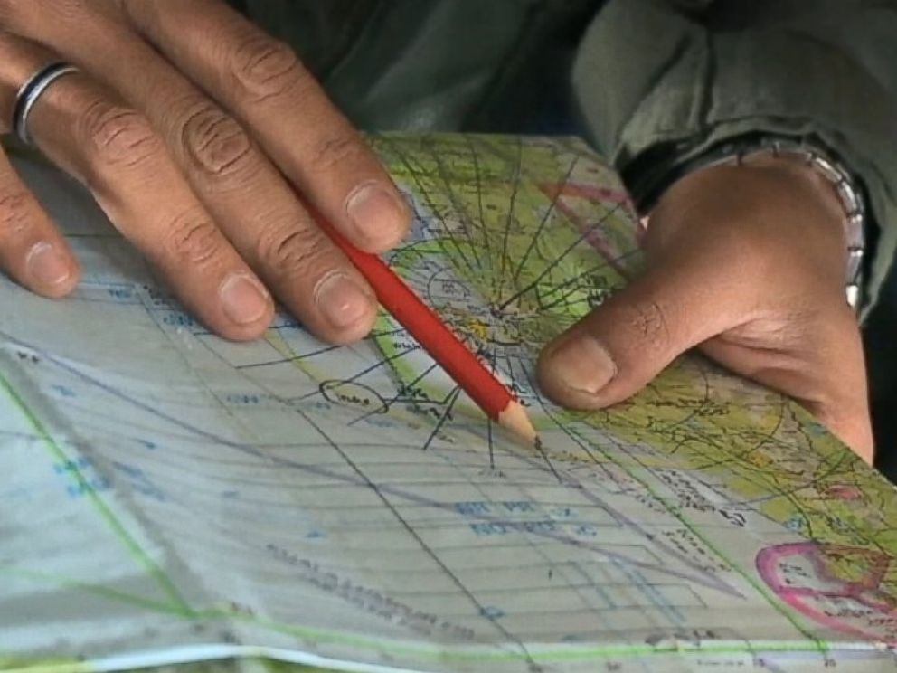 PHOTO: Members of the planes search team check map locations during the flight.