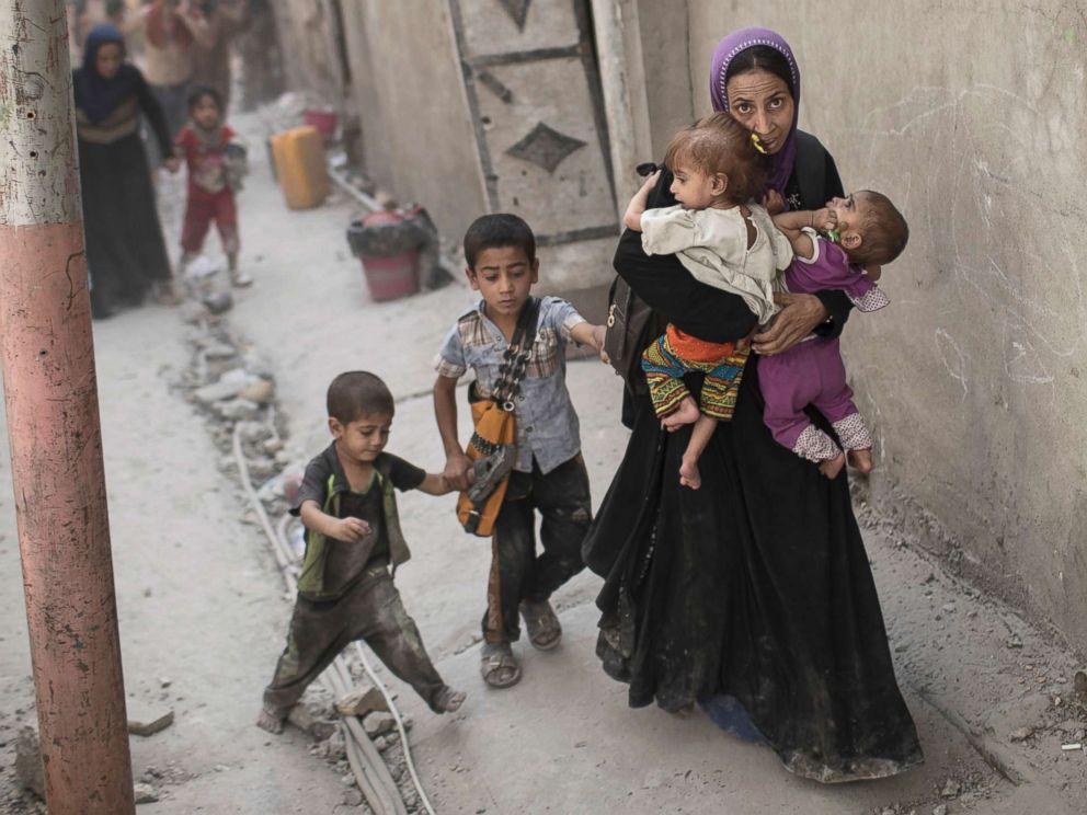 PHOTO: Iraqi civilians flee through an alley as Iraqi Special Forces continue their advance against Islamic State militants in the Old City of Mosul, Iraq, July 3, 2017.