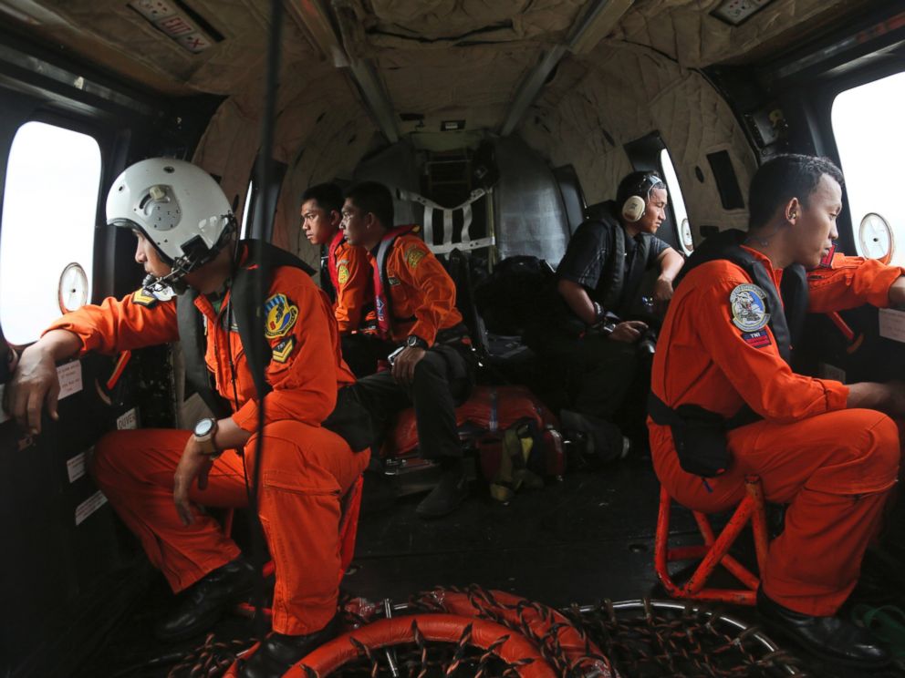 PHOTO: Crewmembers of Indonesian Air Force NAS 332 Super Puma helicopter look out of the windows during a search operation for the victims and wreckage of AirAsia Flight QZ 8501 over the Java Sea, Indonesia, Jan. 5, 2015.