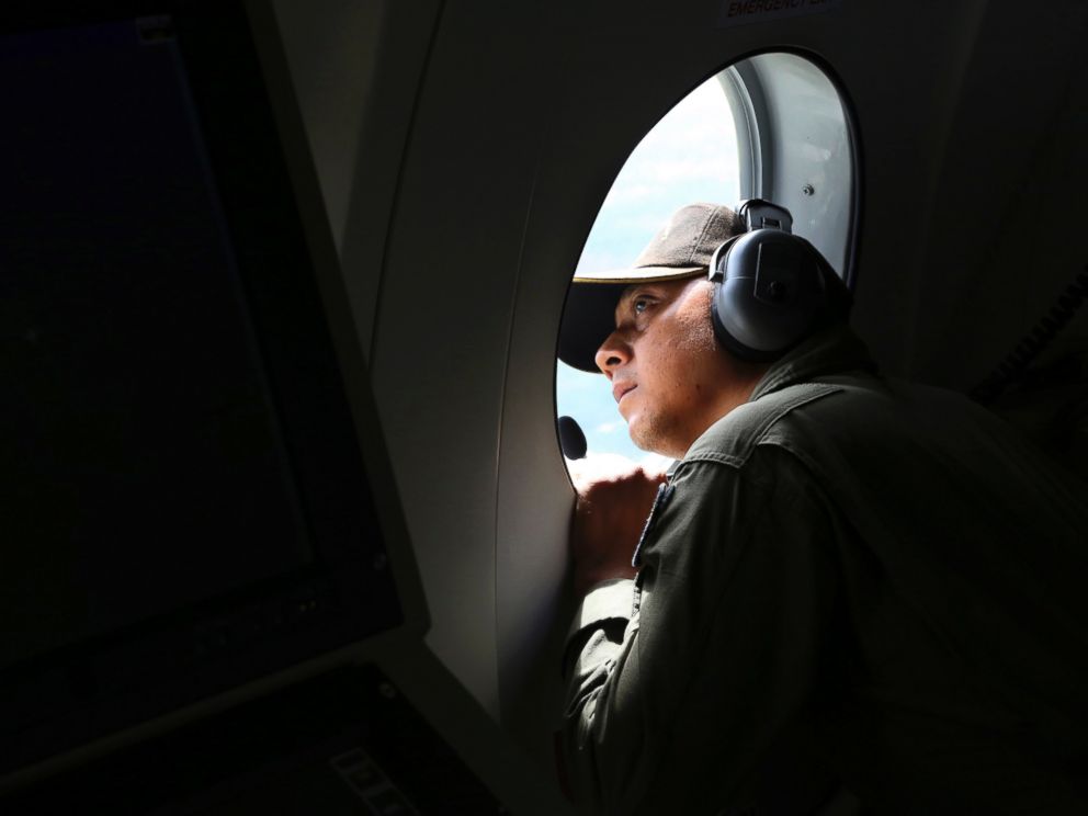 PHOTO: A crew member of Indonesian Navy CN-235 airplane looks out of the window during a search operation for the missing AirAsia flight 8501 over the waters off Bangka Island, Indonesia, Dec. 30, 2014.